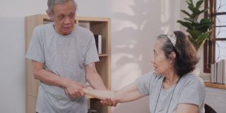 老年男医护人员在家伸展老年女病人的手臂