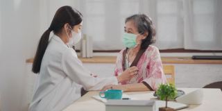 亚洲女护士在家庭护理员上伸展老年女病人的手臂