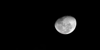 夜晚，月亮挂在黑色的天空上，乌云从它上面掠过。阴森可怕的夜空，乌云密布，满月皎洁。
