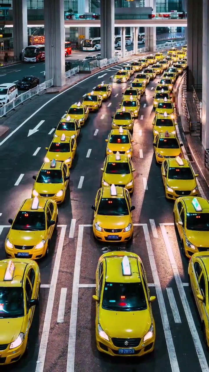 夜间在机场出口排队的黄色出租车