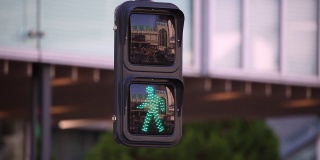 行人交通信号灯绿灯闪烁转为红灯。在日本东京，人们正在过马路
