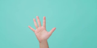 人的手举起的特写镜头，做出用手指倒数的手势。用手掌打旗号或做手势的人。在孤立的蓝屏背景中看到。