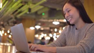 亚洲女性自由职业者使用她的笔记本电脑和工作在咖啡店视频素材模板下载