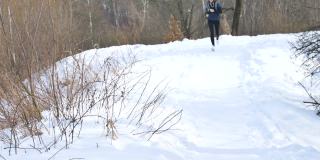 穿着深色运动服跑步的年轻女孩正在城市公园里穿着冬季羊毛衫慢跑。健康与健身理念。