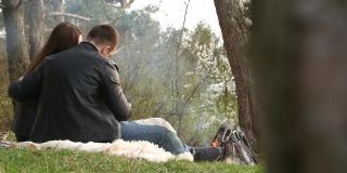 一对情侣在夏天的公园野餐。放松的男人和女人花时间在户外。