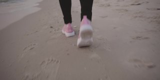 腿的特写亚洲成熟的女人在海滩上跑步