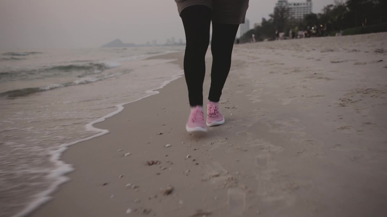 在海滩上跑步的成熟亚洲女人