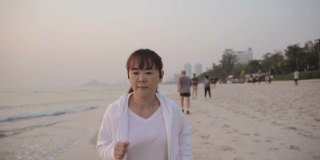 在海滩上跑步的成熟亚洲女人