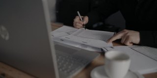 坐在笔记本电脑旁边的商人可以在合同文件上签字。商业伙伴。软焦点视频。