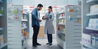 药店:女性亚洲药剂师帮助拉丁男性客户与推荐，并建议购买药物，药物，维生素。现代药店货架与保健产品