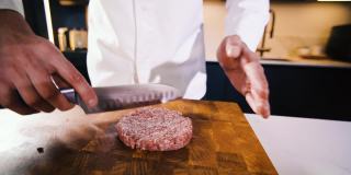 厨师准备肉汉堡肉排从新鲜切碎的肉与他的手。在餐厅厨房做饭。准备晚餐的人。制作美味的汉堡。美味家常菜特写