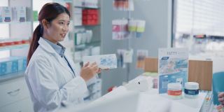 药店收银柜台:专业亚洲女性药剂师销售药品包装，讲解如何使用，客户使用非接触式支付终端和信用卡支付