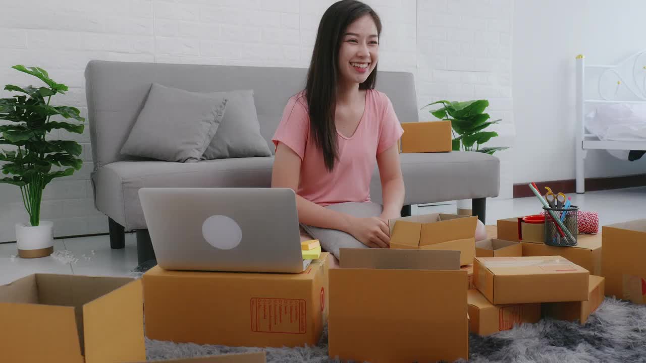 网上商店的小企业主，女性亚洲企业家包装邮船箱准备交付包裹客户