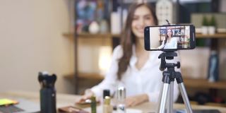 亚洲年轻女性博主录制视频与化妆化妆在家在线影响社交媒体概念。直播病毒