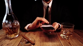一个穿着黑色服装坐在酒吧里扔钞票的富人的特写镜头视频素材模板下载