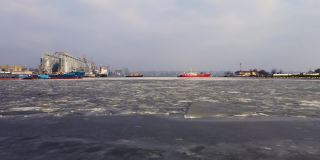 无人机拍摄到货运站的船只、码头上的港口起重机和粮食储存罐正在融冰