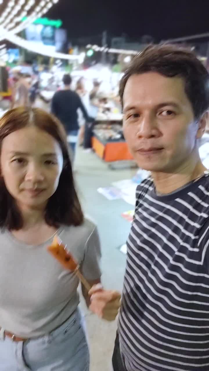 一对夫妇吃着肉丸，泰国街头小吃