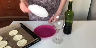 一位妇女把未发酵的玉米粉放在盘子里。旁边有一瓶干红葡萄酒