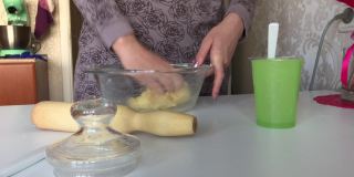 一个女人用玉米面做面团。用手混合面粉和水。使无酵饼。