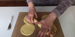 一个妇女用玉米面做无酵面包。使面团成形。面团放在不粘的垫子上。