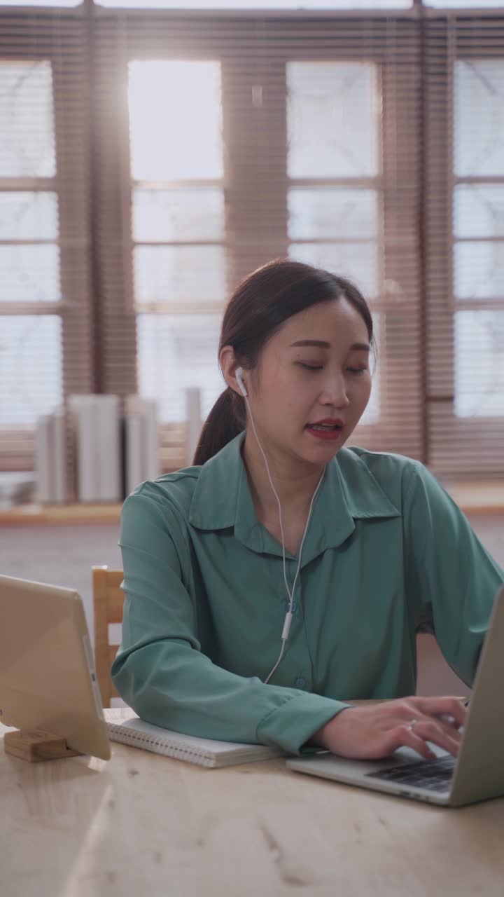 亚洲华人女性在家中使用笔记本电脑进行视频电话会议
