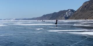 一群游客在结冰的贝加尔湖上溜冰。