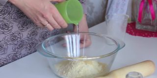 一个女人用玉米面做面团。混合面粉和水。使无酵饼。特写镜头