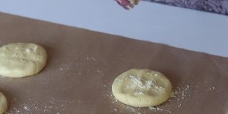 一位妇女往玉米面面团上撒面粉。准备无酵饼。特写镜头。