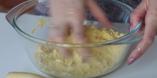一个女人用玉米面做面团。用手混合面粉和水。使无酵饼。特写镜头