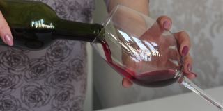 一位妇女将干红葡萄酒倒进玻璃杯。旁边一盘未发酵的玉米粉上。特写镜头。