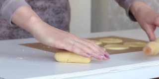 那个女人把面团擀开。用玉米粉准备未发酵的面包。从侧面近距离拍摄。