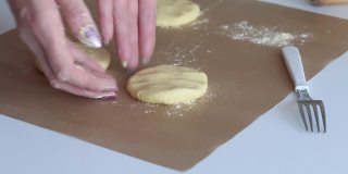 这位妇女把玉米面块铺在不粘的垫子上。准备未发酵的面包。特写镜头。