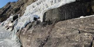 春天在山上。小溪从峭壁上奔流而下。岩石上的雪和冰。