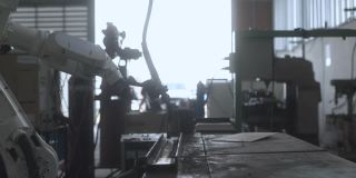 工业4.0概念现代自动化机器人焊接臂机床焊接金属管道和钢板与明亮的火花和烟雾在生产工厂车间的事实背景
