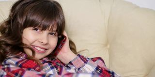 一个十几岁的女孩用她的智能手机在社交网络上交换信息，享受移动技术
