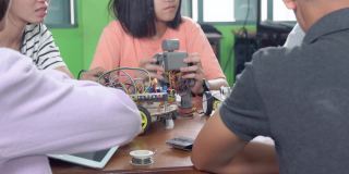 中学阶段:教师向孩子们讲解如何使用机器人程序，让孩子们饶有兴趣地学习。