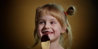 快乐的小女孩舔融化的巧克力，孩子吃，享受不健康的甜食室内