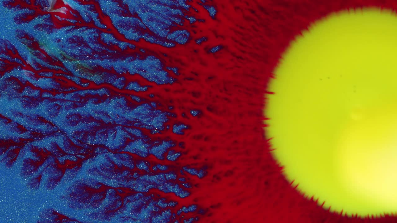 水晶发芽。抽象的黄色，红色的点在蓝色的背景。抽象的垃圾艺术，墨水颜料扩散爆炸的背景。
