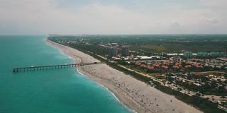 在朱诺海滩码头鸟瞰图，佛罗里达州与明亮的蓝色海水正午在春假期间在2021年3月