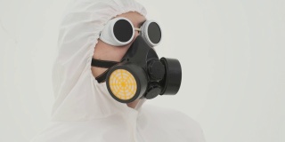 特写的人在防护服上戴着防毒面具自己。在白色背景上拍摄。