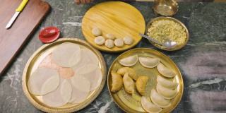 一位印度妇女正在准备古嘉，一种印度流行的小吃，特别是在胡里节的颜色