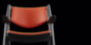 4k现代扶手椅橙色皮革和黑色木材。现代家具。旋转。循环。副本的空间。没有聚焦的背景。