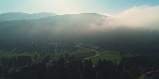 日出在雾蒙蒙的森林和山区景观，4k航拍视频