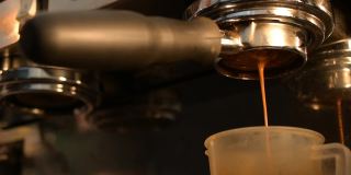 一段视频显示，一台浓缩咖啡机用一个“裸”门式过滤器制作浓缩咖啡，将高压热水导入咖啡冰球中。