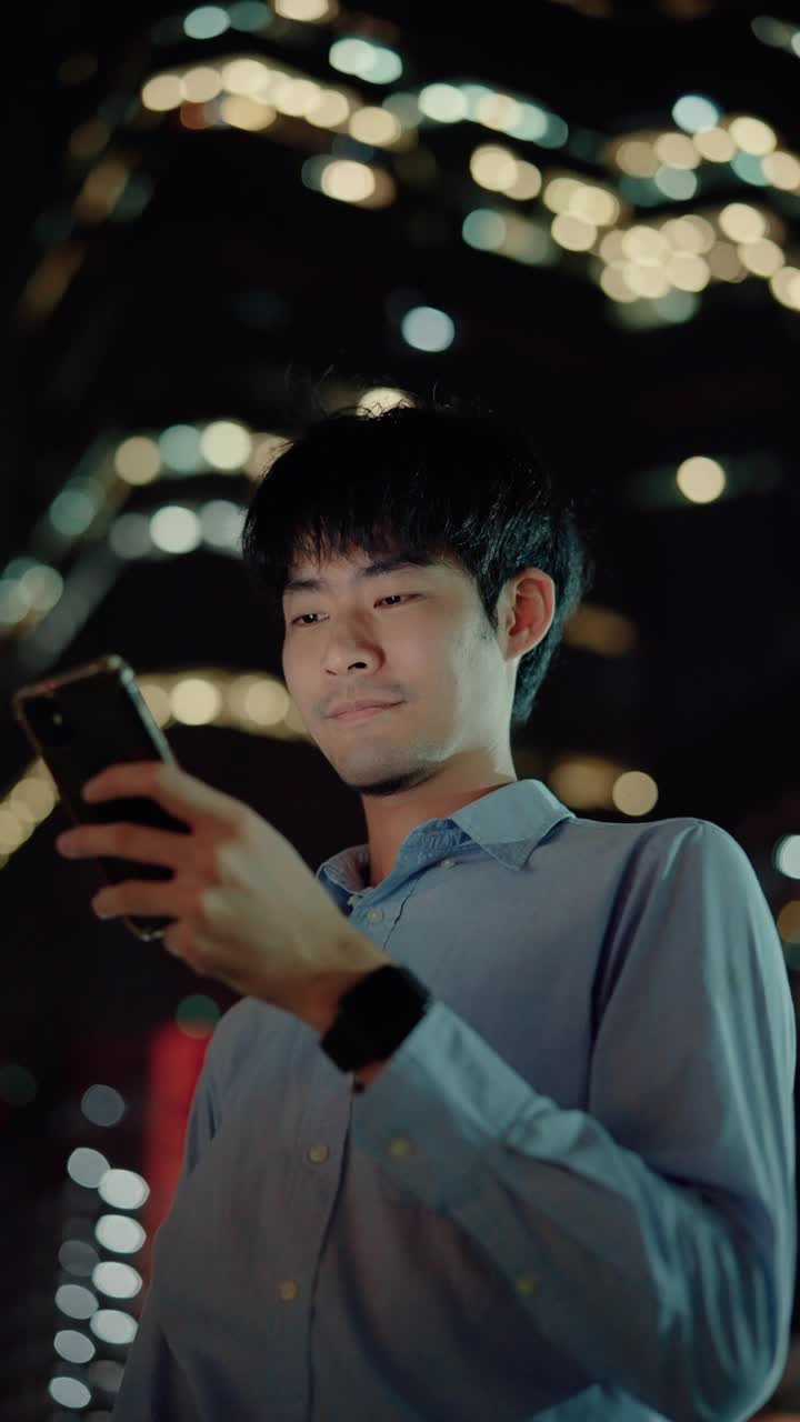 一个商人晚上在城里用手机。