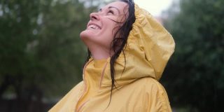 快乐的女人在雨中微笑。爱、自然、幸福、自由的概念。