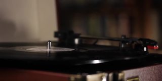 手把唱机的唱针放在旋转的黑胶唱片上。