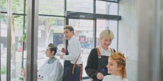 亚洲专业发型师团队为年轻顾客提供美容院服务。发型师检查年轻女性的发型，理发师在理发店为男孩梳理和剪头发