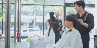 亚洲专业男女美发师在美容院或理发店用剪刀和梳子为顾客理发。年轻友善的造型师交谈，让顾客感到舒适和放松。