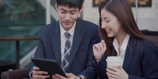 亚洲男性和女性聊天和一起工作用笔记本电脑开始小生意